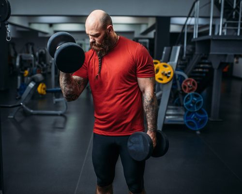 athlete-doing-exercise-with-dumbbells-in-gym-7FYAZM2-min.jpg