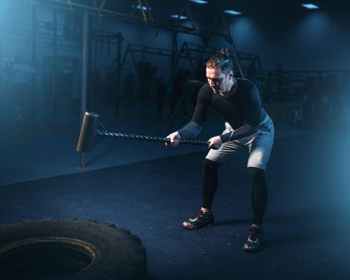 training-in-gym-man-with-sledgehammer-hits-tire-PC3UH98-min.jpg